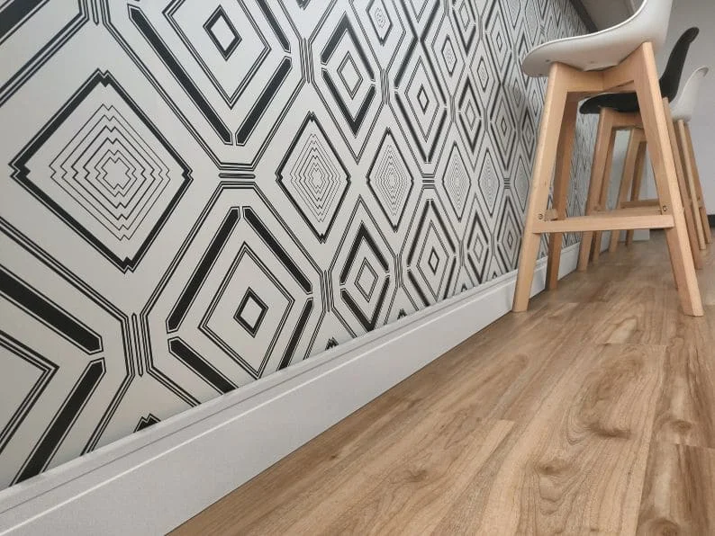 Zócalo con iluminación LED en muro interior y piso de madera clara